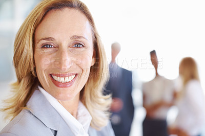 Buy stock photo Closeup of mature female professional smiling with associates in background