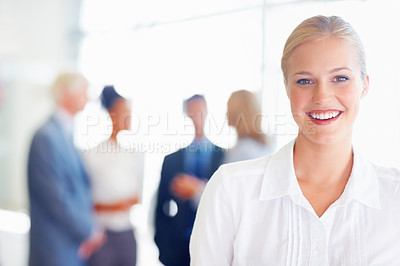 Buy stock photo Closeup of young female professional smiling with associates in background