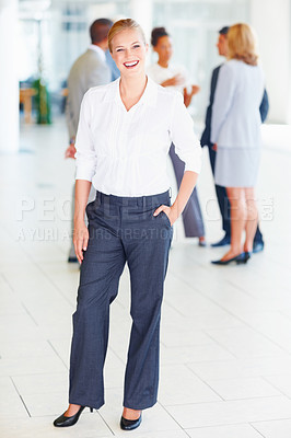 Buy stock photo Full length of attractive female executive smiling with business people discussing in background