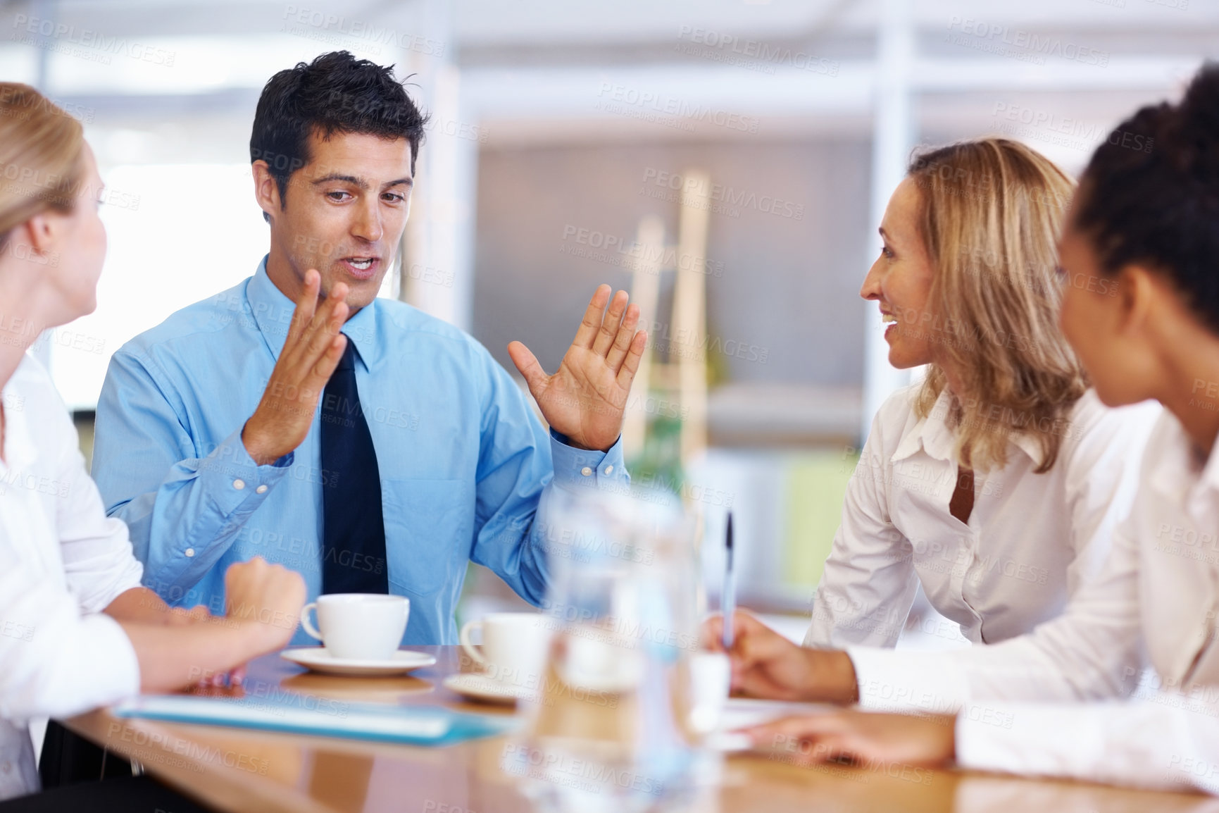 Buy stock photo Portrait of young business man expressing his views to female executives during meeting