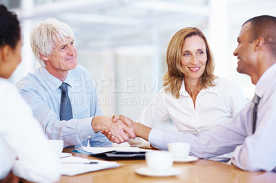 Buy stock photo Portrait of senior executive shaking hands with young business man at office
