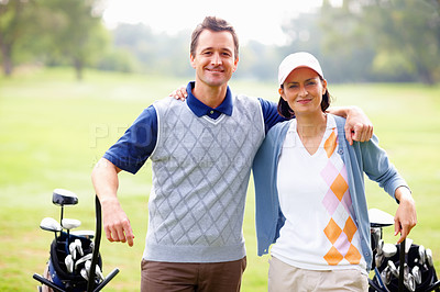 Buy stock photo Portrait of happy couple standing on golf course with arms around and smiling