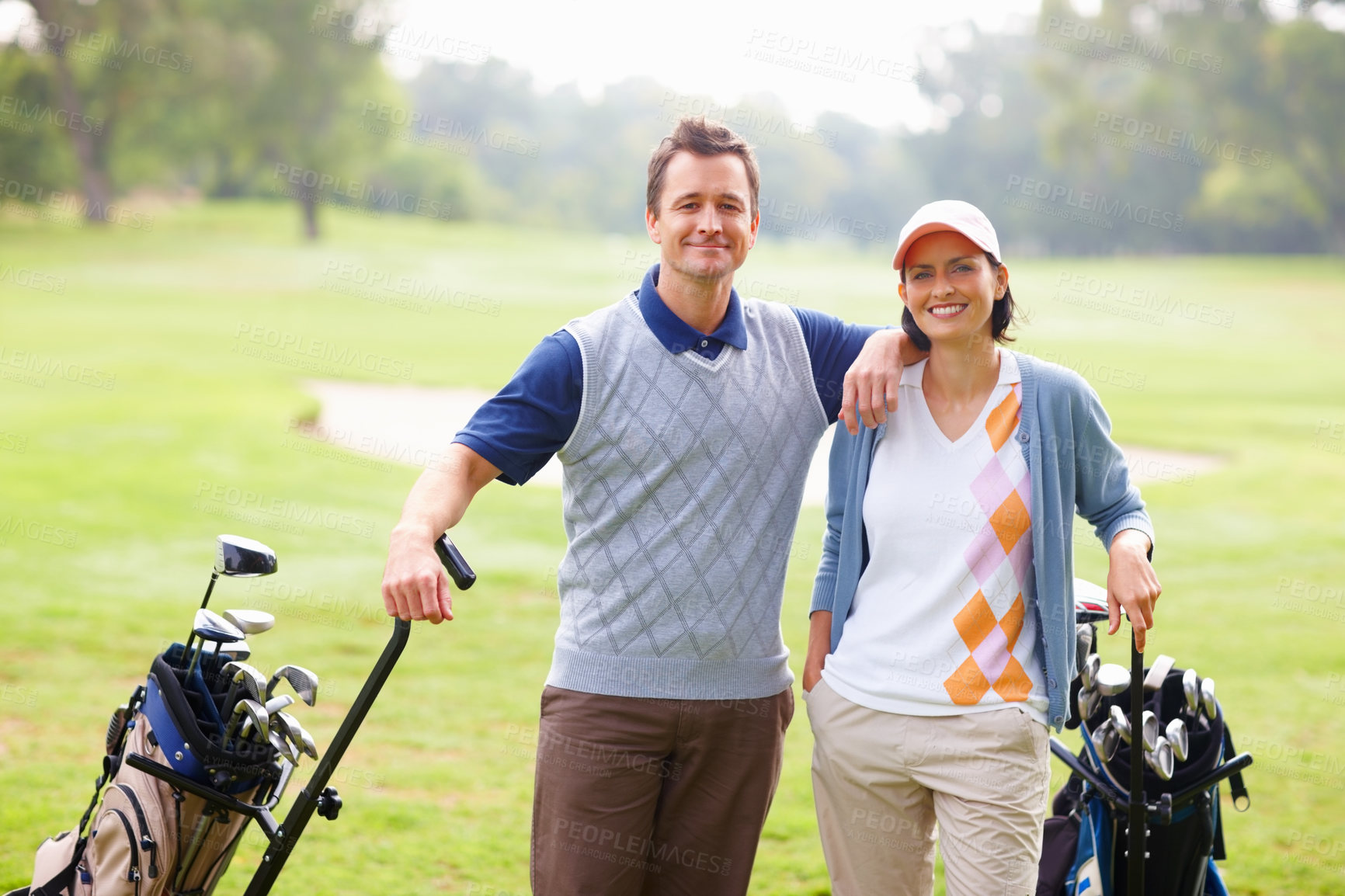 Buy stock photo Portrait of couple standing on grass with golf kit and smiling