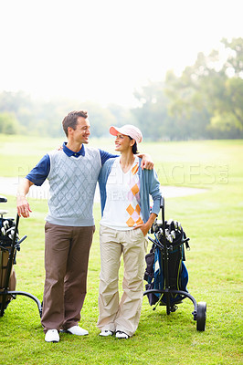 Buy stock photo Full length of happy golfing couple with arms around smiling and looking at each other