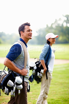 Buy stock photo Man and woman carrying golf bags and looking away