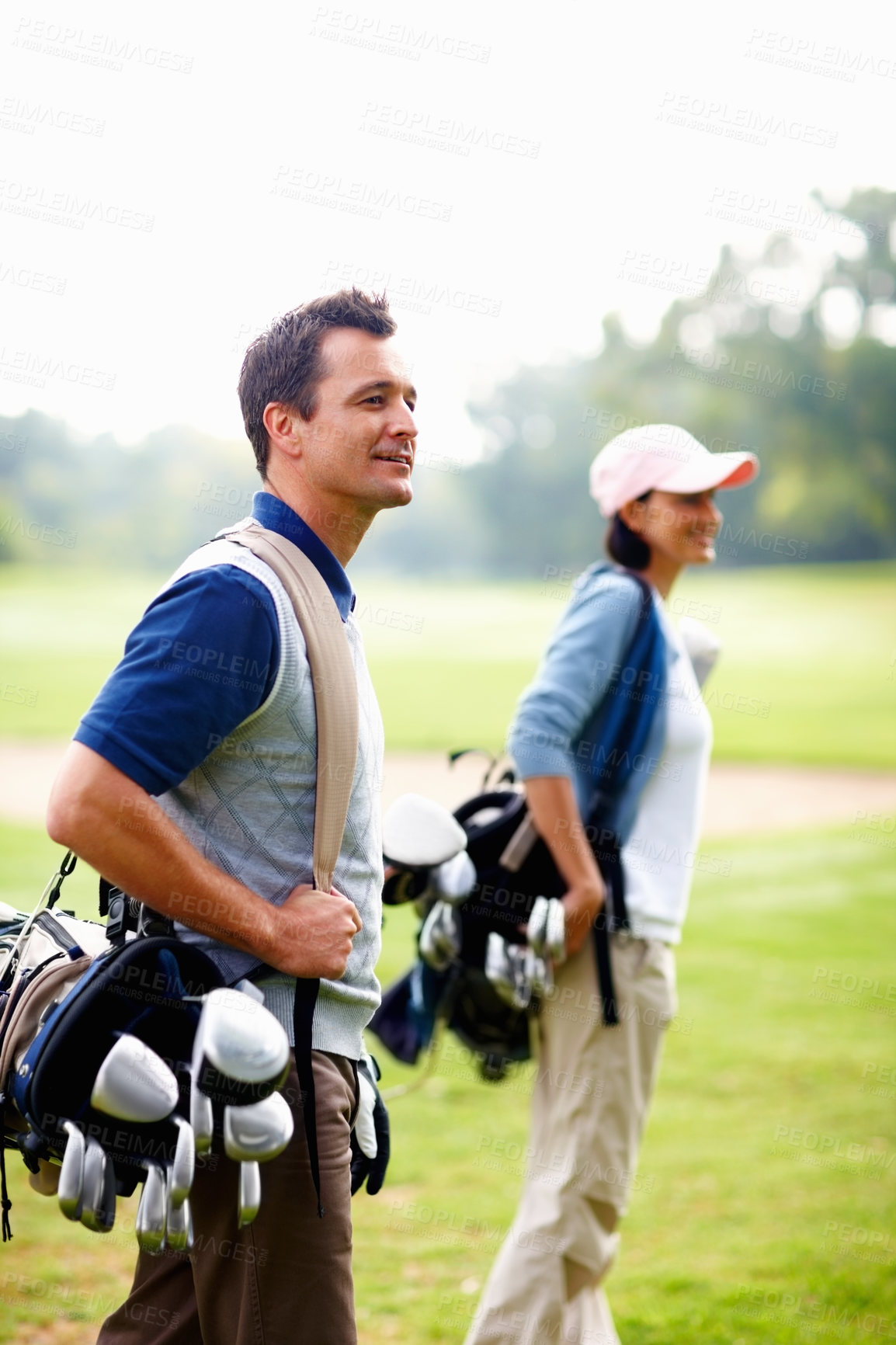 Buy stock photo Golf, walking and couple on course with bag, smile and teamwork on outdoor fitness adventure. Support, woman and man on green for sports date at club with partnership, health and wellness together