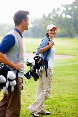 Buy stock photo Focus on smiling woman carrying golf bag and looking at man