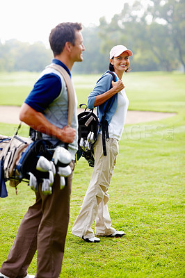 Buy stock photo Couple carrying golf bags and walking on golf course