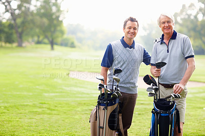 Buy stock photo Portrait of father and son standing with golf bags and smiling