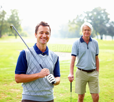 Buy stock photo Portrait of smart man holding a golf club and smiling with father standing in background