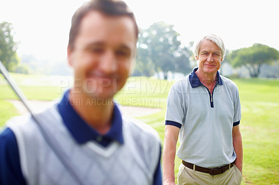 Buy stock photo Portrait of senior man standing on golf course and smiling with son in foreground