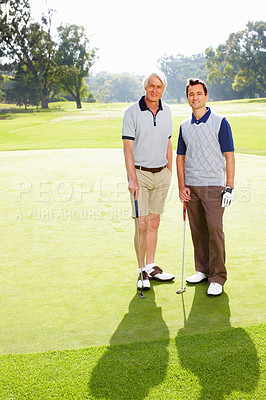 Father and son standing on golf course