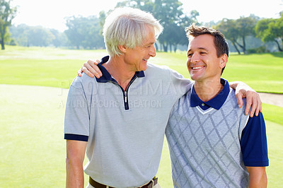 Buy stock photo Portrait of father and son on the golf course smiling and looking at each other