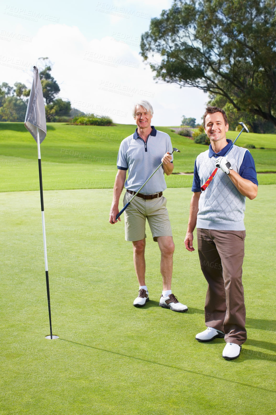 Buy stock photo Father, son and portrait for golf, sports and bonding outdoor with equipment, hole and family vacation. Elderly person, man and smile on grass for hobby, talking and playing game at country club