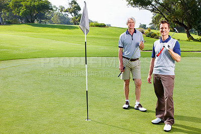 Buy stock photo Full length of smiling father and son standing on the putting green with golf clubs