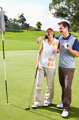 Buy stock photo Portrait of couple standing on the golf course near flagstick and smiling