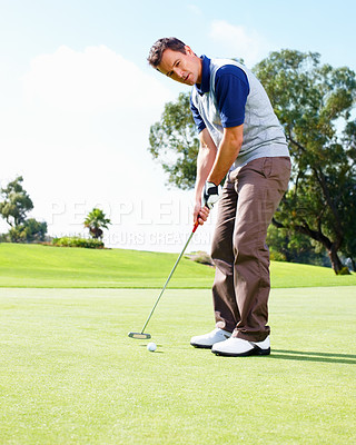 Buy stock photo Full length of male golfer about to putt the ball