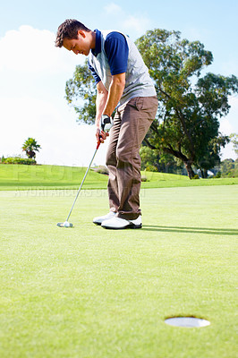 Buy stock photo Full length of man playing golf and taking position to putt the ball in the hole