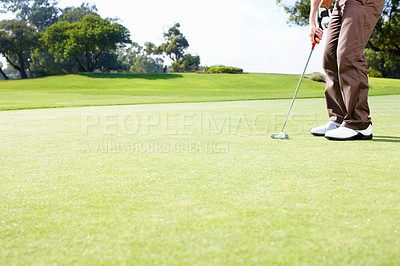 Buy stock photo Low section of golfer in position to putt the ball