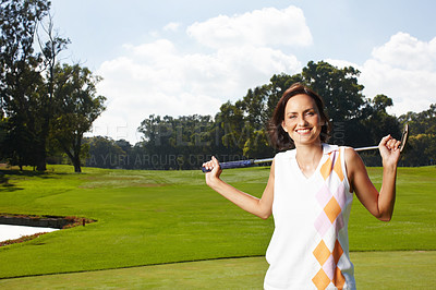 Buy stock photo Portrait of one beautiful young woman standing on the golf course and holding her club over her shoulders. Confident female golfer in sports uniform smiling at camera. She's on par for handicap
