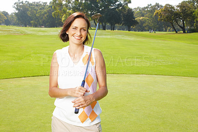 Buy stock photo Young woman standing on the golf course and holding her club over her shoulders