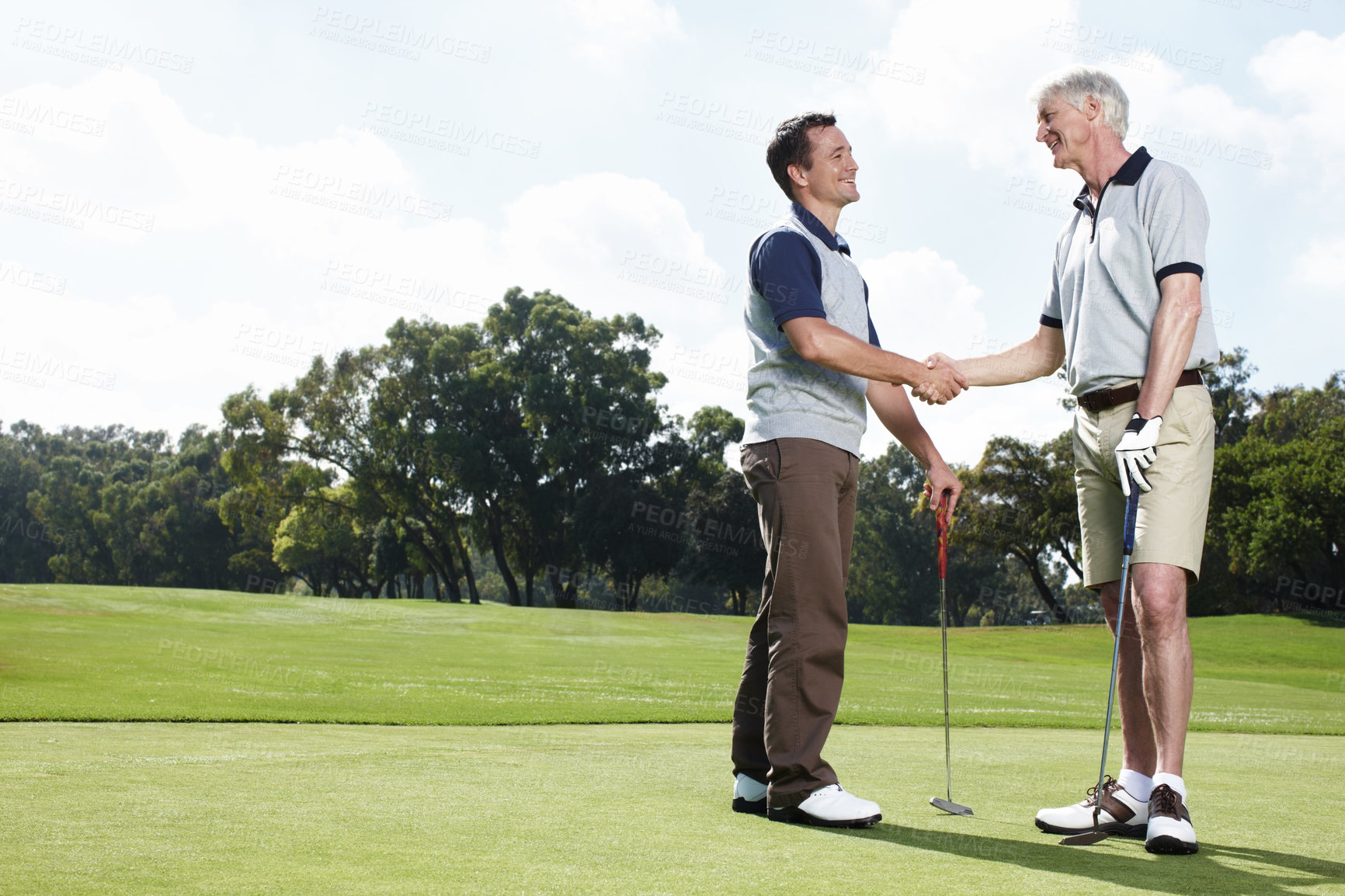 Buy stock photo Support, handshake and men on golf course together for teamwork, outdoor fun and fitness competition at club. Sports, senior father and son shaking hands on green for partnership, bonding and game.