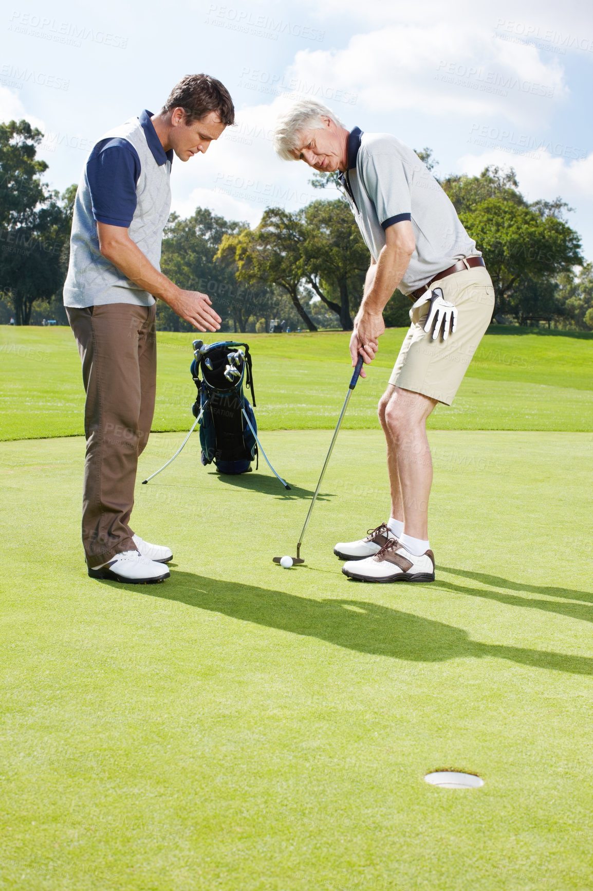 Buy stock photo Two men playing a round of golf together on the green