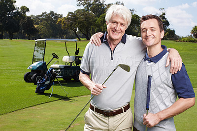 Buy stock photo Father and son golfing team on the green with their golf cart in the background
