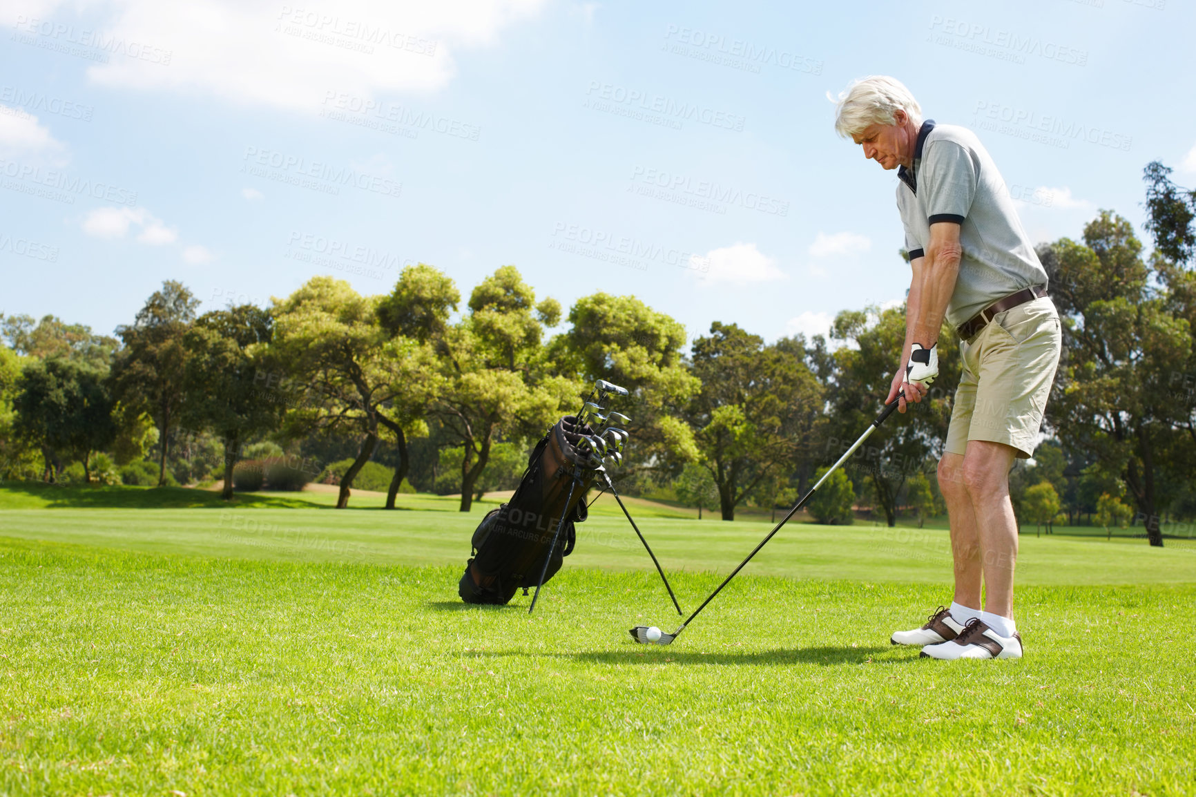 Buy stock photo Senior man getting ready to swing on the golf course