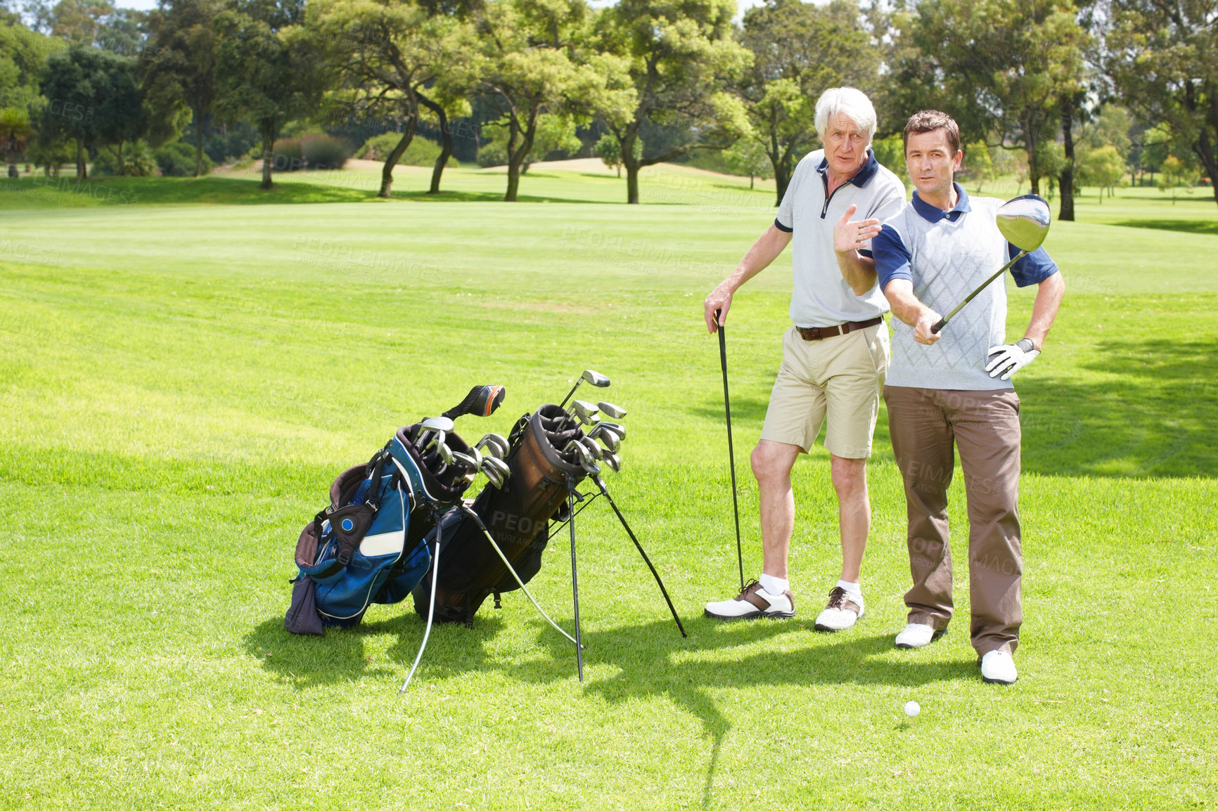 Buy stock photo Advice, play and men on golf course together for teamwork, outdoor fun and fitness competition in nature. Sports, senior father and son on green for partnership, bonding and support in club challenge