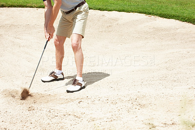 Buy stock photo Senior man trying to hit his ball out of the sandtrap on the golf course
