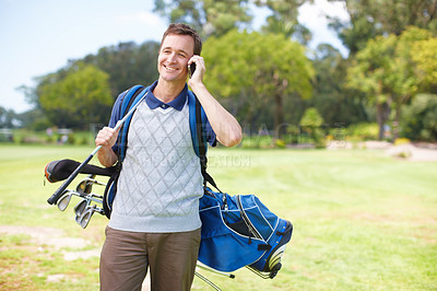 Buy stock photo Smiling golfer using his mobile on the course while carrying his clubs