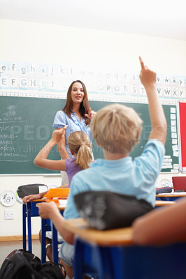 Buy stock photo A pretty young teacher standing at the class blackboard teaching 