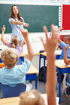 Buy stock photo Question, students and answer teacher in classroom for learning, assessment and education support. Smart children, lesson and hands raised with knowledge, exam test and pointing at elementary school