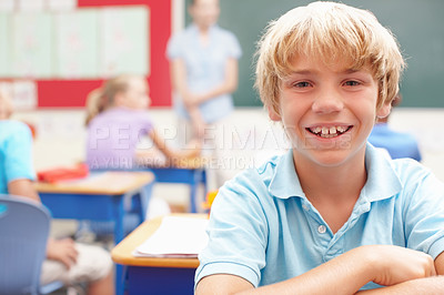 Buy stock photo Happy, portrait and boy at desk in classroom for learning, growth and child development in education. Smile, face and student in school for knowledge, study and future opportunity with scholarship.