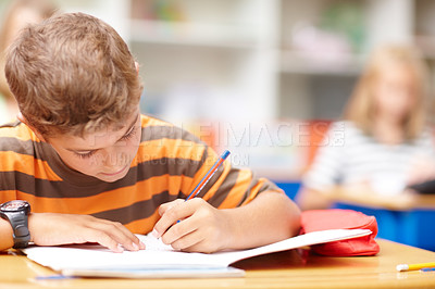 Buy stock photo Writing, books and child in classroom for learning, education and lesson for development. Primary school, academy and young boy with pencil for assignment, creativity and language test for knowledge