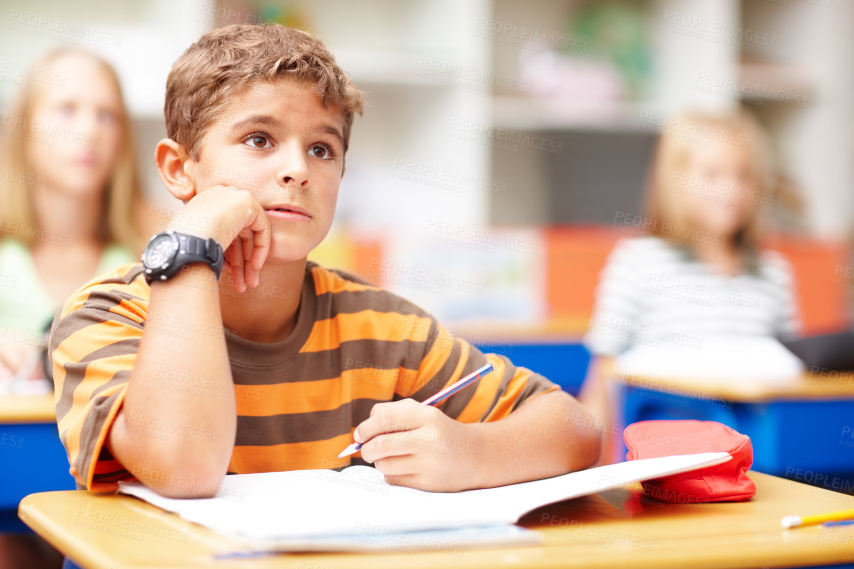 Buy stock photo Young boy in class listening to his teacher while taking notes - copyspace