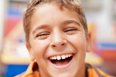 Buy stock photo Laughing, portrait and boy in classroom for learning, growth and child development at elementary school. Happy, face and student at desk for education, study and future opportunity for scholarship.