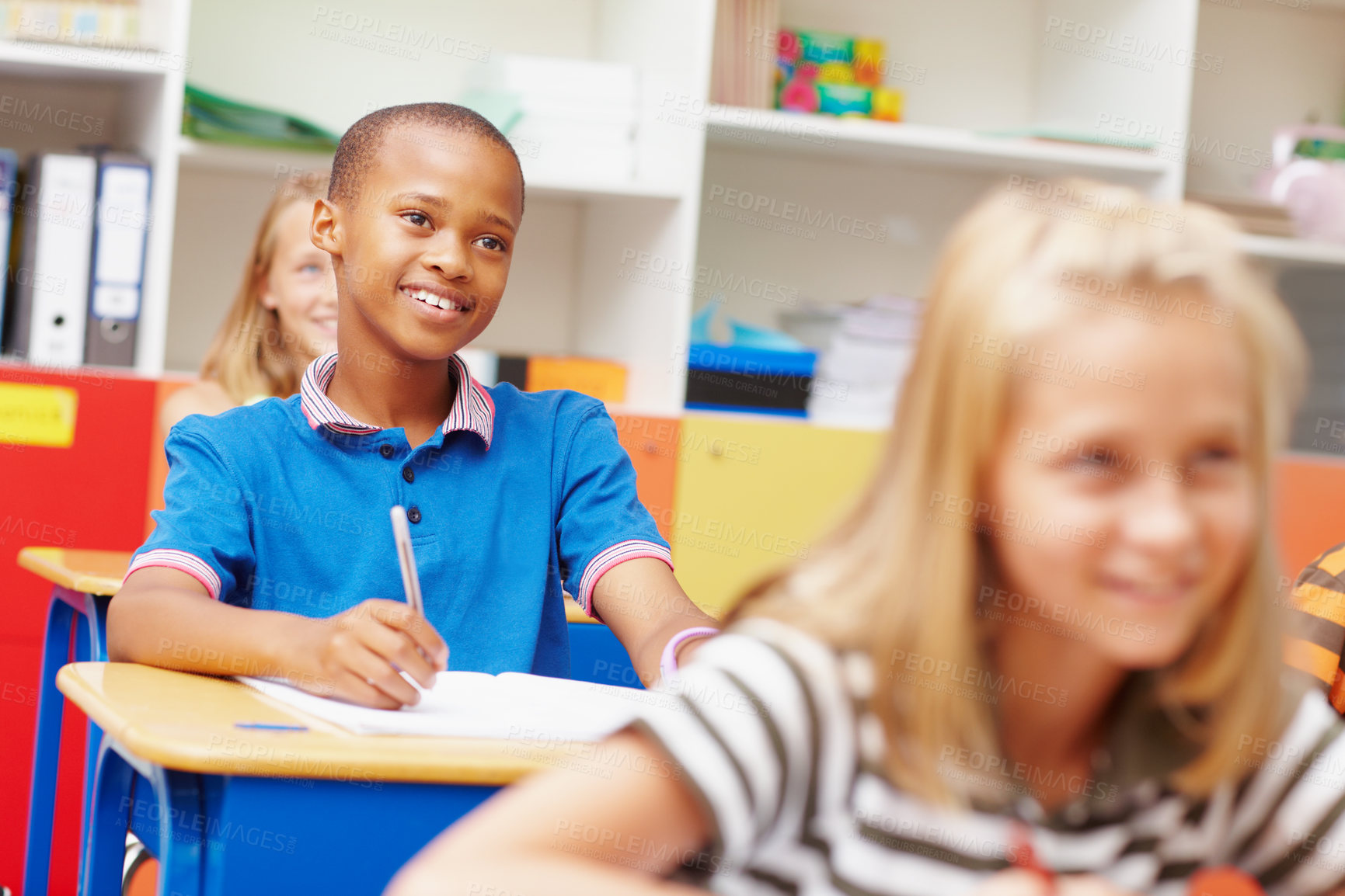 Buy stock photo Young african-american student smiling at his desk in class amongst classmates - copyspace