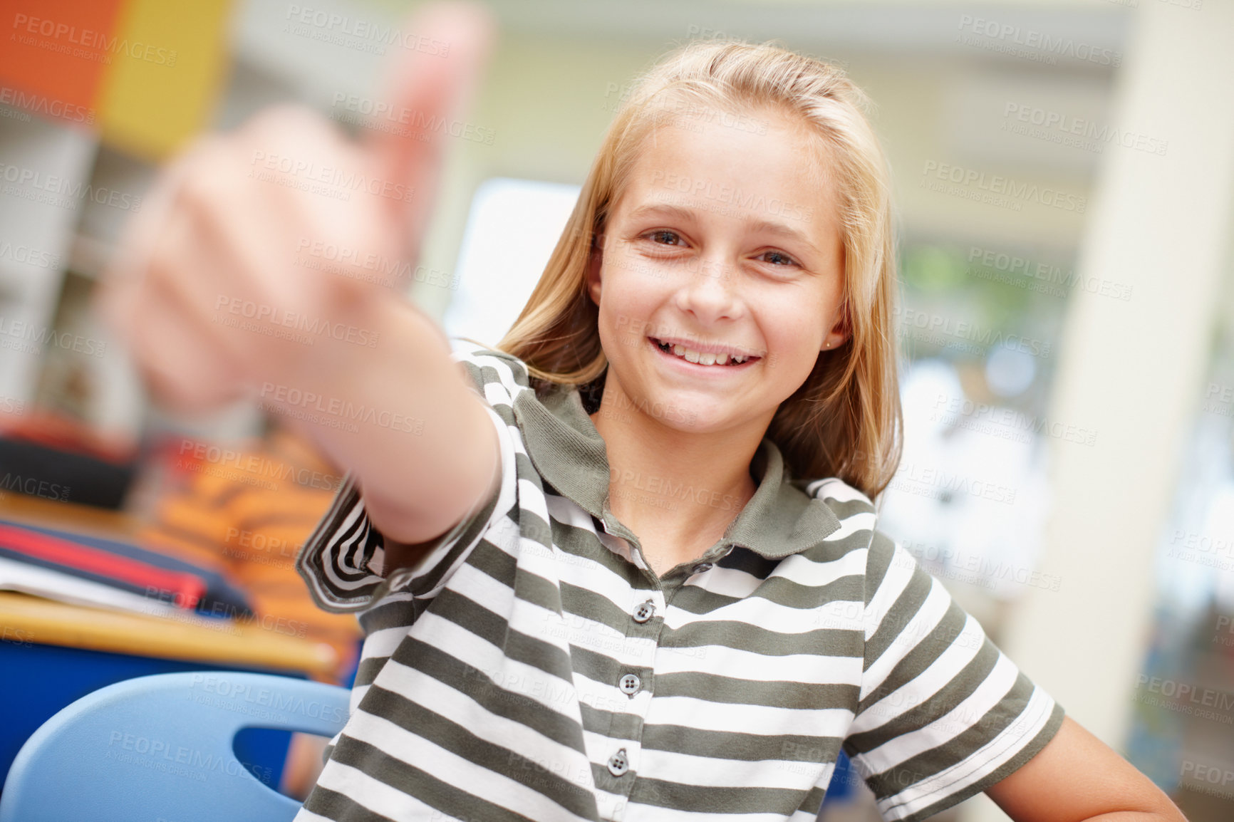 Buy stock photo Sweet elementary school girl giving you a thumbs up - focus on background