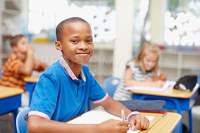 Buy stock photo Writing, happy and portrait of child in class for learning, education and lesson for development. Primary school, academy and young boy with books for practice, test and assignment for knowledge