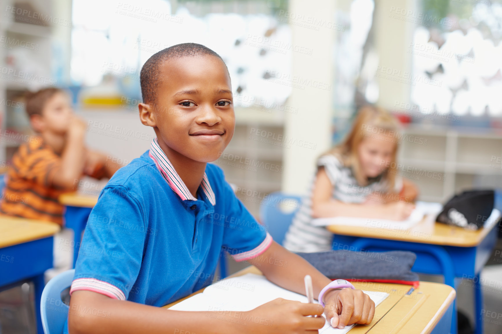 Buy stock photo Writing, happy and portrait of child in class for learning, education and lesson for development. Primary school, academy and young boy with books for practice, test and assignment for knowledge