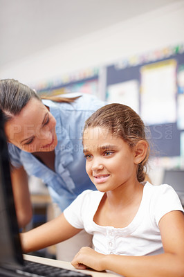 Buy stock photo A beautiful young teacher assisting a cute schoolgirl in computer class