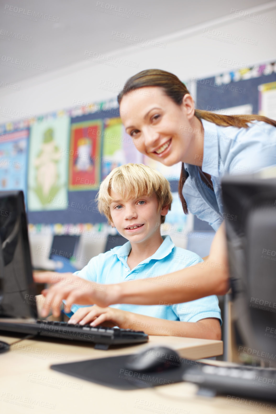 Buy stock photo Woman, teacher and happy with boy on computer in classroom for help, teaching and learning. People, educator and smile on portrait with student at elementary school for education or brain development