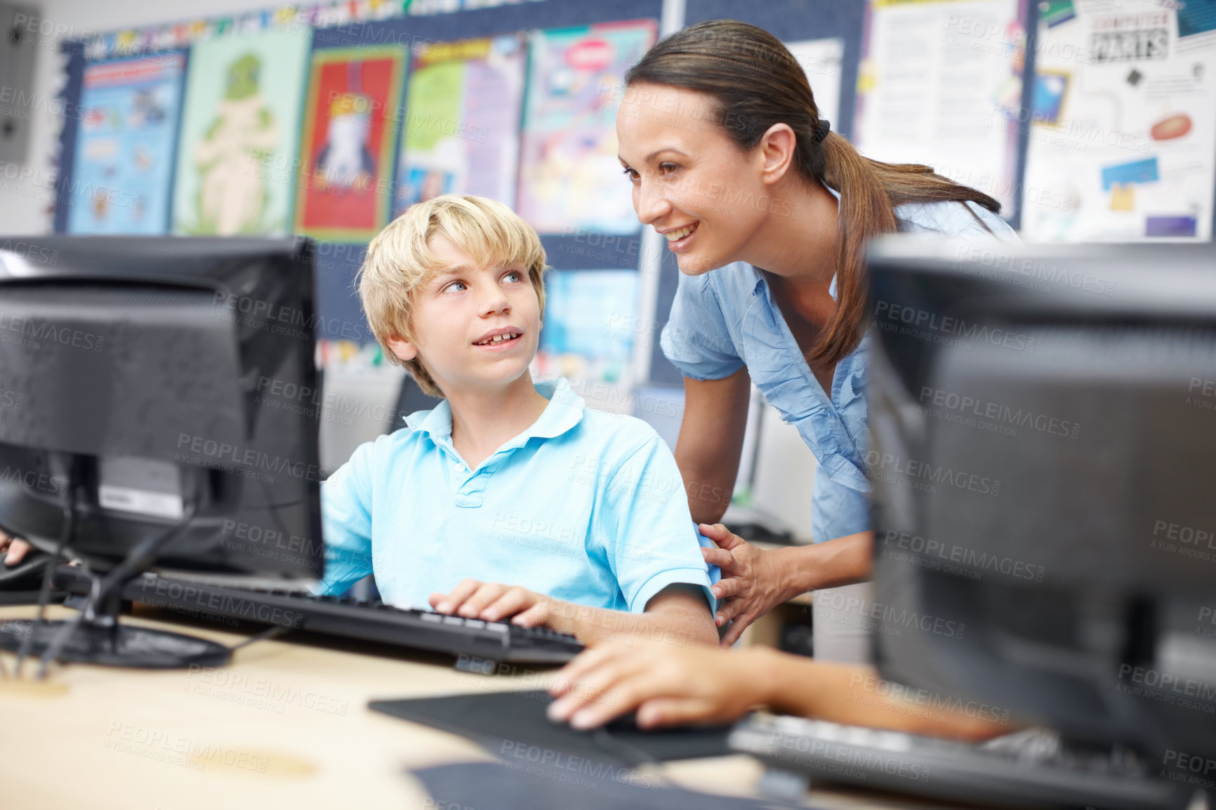 Buy stock photo Woman, teacher and smile with boy on computer in classroom for helping, teaching and learning. People, educator and happy online with student at elementary school for education and brain development