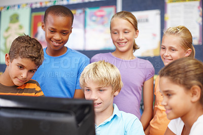 Buy stock photo A group of young friends sitting and standing around a computer during class
