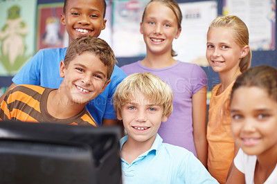 Buy stock photo Portrait of a group of cute kids sitting and standing around a computer during class