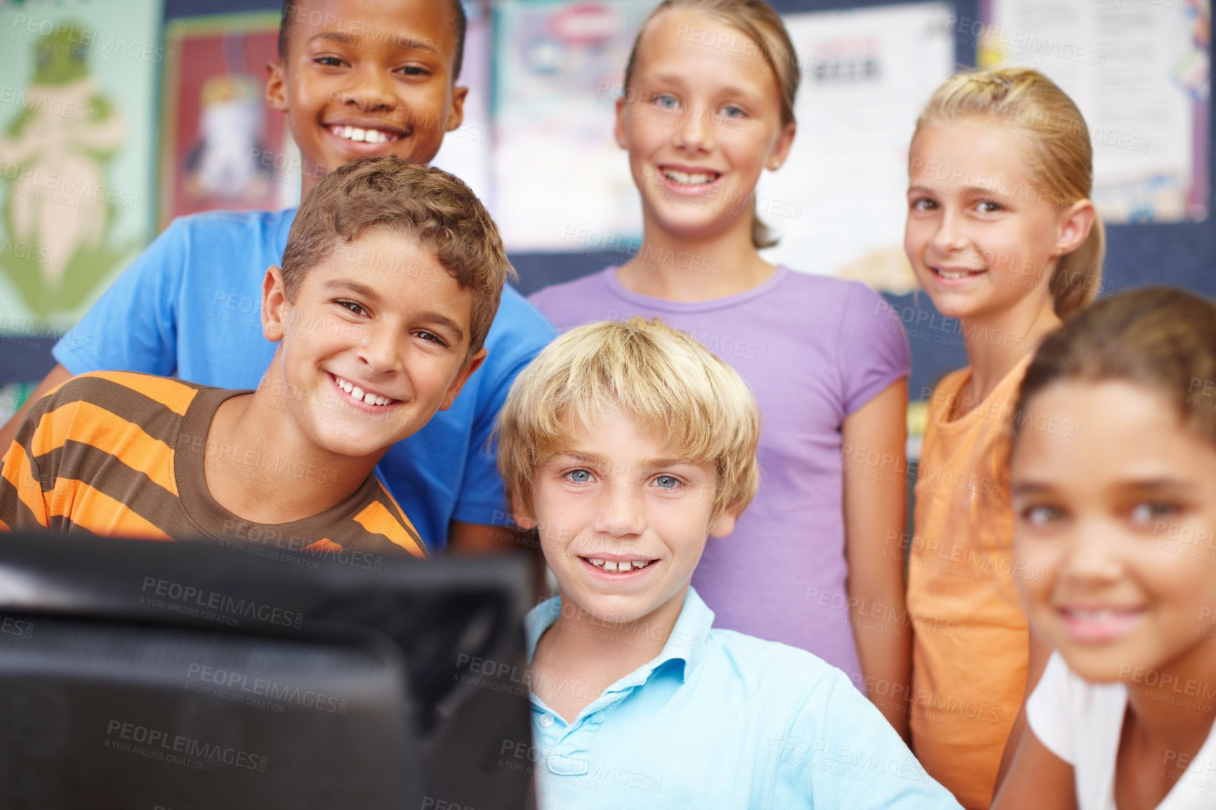 Buy stock photo Portrait of a group of cute kids sitting and standing around a computer during class