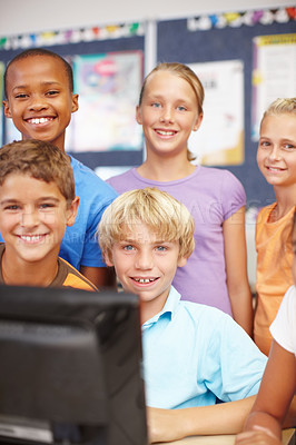Buy stock photo Portrait of a young group of kids sitting and standing around a computer during class
