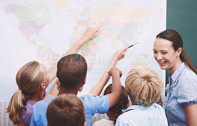 Buy stock photo A group of children looking at a world map during geography class
